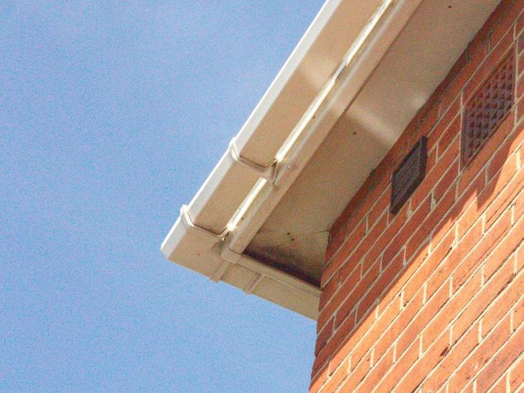 Clean white soffit, fascia and gutter on a brick house
